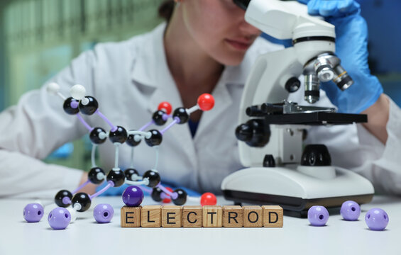 A researcher examines samples through a microscope in a laboratory setting, showcasing molecular models.
