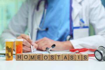 A doctor writing prescriptions with medication containers highlights the importance of homeostasis in health.
