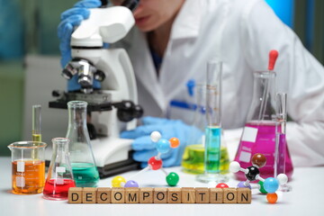 A scientist examines samples under a microscope in a colorful lab focused on decomposition research.