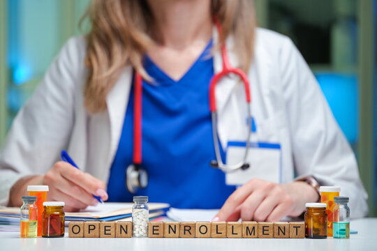 A healthcare provider is discussing various open enrollment options while surrounded by medication bottles
