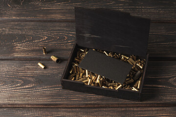 Invitation, greeting card or mock certificate in a wooden box with spent cartridges.
