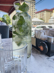 Lemonade in a carafe on a table in a cafe. Selective focus.
