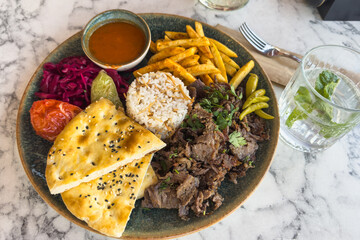 A plate of doner kebab salad and French fries. Traditional Turkish cuisine.