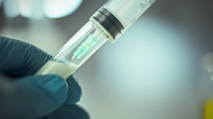 A laboratory technician wearing gloves is carefully loading a syringe with a liquid sample in a sterile lab setting. This activity is crucial for conducting accurate scientific tests - Powered by Adobe