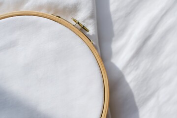 Close-up View of an Embroidery Hoop on a Plain White Fabric Surface