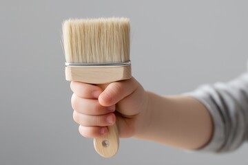 Toddler Explores Creativity With Paintbrush in Hand and Slight Paint Marks
