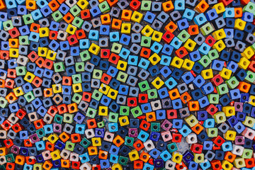 Wide mosaic walkway of multicolor square blocks with round holes , arranged in an alternating pattern. Ideal for abstract backgrounds and creative texture design.