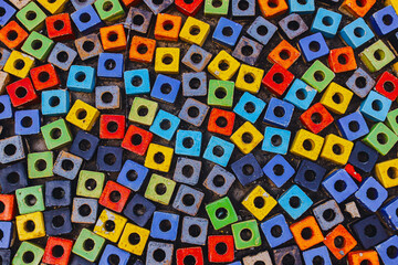 Close-up of colorful square paving blocks with round holes , arranged in a playful alternating pattern. Perfect for abstract backgrounds , creative textures or urban design.