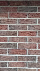 Red and brown brick wall with natural texture and uneven coloration — classic construction...