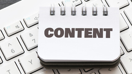 CONTENT word in a small office notebook placed on the keyboard. © roobcio