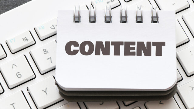 CONTENT word in a small office notebook placed on the keyboard.