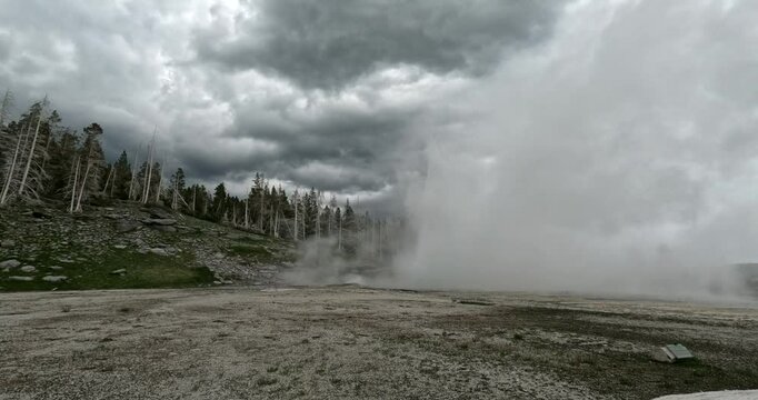 Grand Geyser Eruption In Yellowstone National Park. Fast Moving White Steam And Hot Water Rising Out Of The Earth's Crust Putting On A Majestic Display For Visiting Tourists.