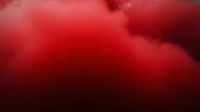 Red smoke bomb exploding, creating a colorful cloud