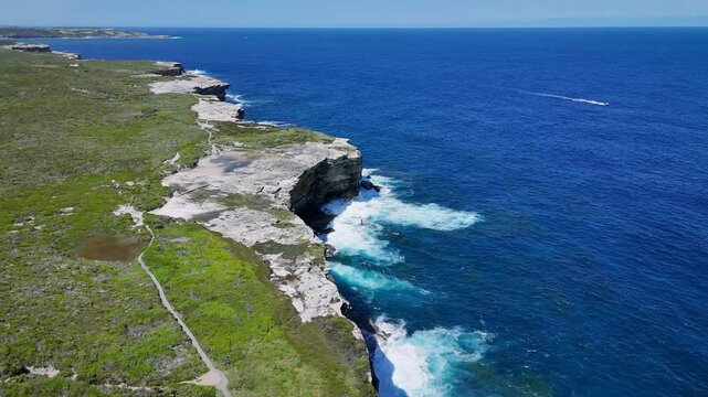 Kurnell, Sydney, Australia - UHD Drone Video - Spectacular cliffs and ocean views of the scenic Cape Baily Lighthouse, in Kamay Botany Bay National Park, with Sydney City views in the background.