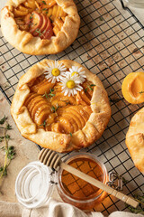 Summer apricot galeta with honey on baking cooling rack on beige table. Summer open tart or pie