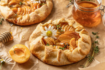 Summer apricot galeta with honey on baking parchment sheet. Summer open tart or pie