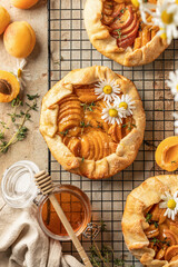 Summer apricot galeta on baking cooling rack on beige table. Summer open tart or pie