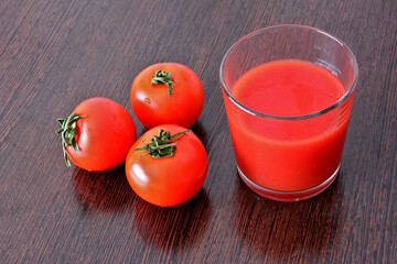 Fresh Tomatoes and Tomato Juice in a Glass on a Wooden Surface