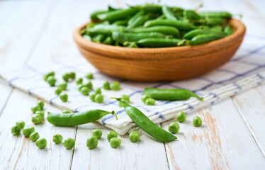 fresh green peas on a white wooden table, selective focus.