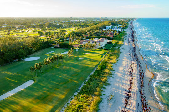 Aerial view of golden sunlight kissing the coastline where emerald golf courses meet the azure ocean, a Florida paradise., Delray Beach, Florida, United States.