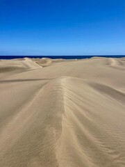 Golden dunes of Saïagha stretching into the horizon. Warm summer desert landscape perfect for adventure travel.