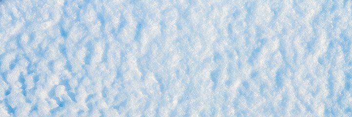 Natural snow texture. The surface of the snow crust. Snowy ground. Winter background with snow patterns. Perfect for Christmas and New Year design. Closeup top view.