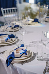 plates with white boxes with sweet gifts for guests.