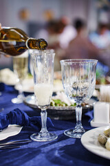 Champagne or sparkling wine is poured into glasses.