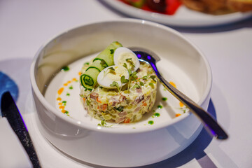 Classic Olivier salad, Moscow salad in a serving plate with a spoon