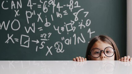 Elementary school student with round eyeglasses peeks over a white desk at a chalkboard filled with complex math equations, appearing curious and engaged in learning - Powered by Adobe