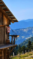 Outdoor sink on a wooden balcony with running water, attached to a rustic house perched on a cliff...