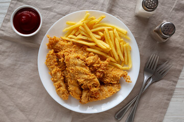 Homemade Chicken Strips with Fries on a Plate, top view.