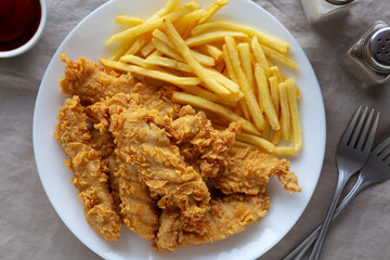 Homemade Chicken Strips with Fries on a Plate, top view.