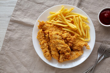 Homemade Chicken Strips with Fries on a Plate, top view.