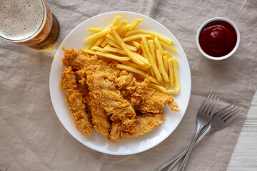 Homemade Chicken Strips with Fries on a Plate, top view.