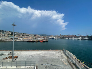Panoramic view of the harbor of Genoa, Italy, with colorful historic buildings, construction...