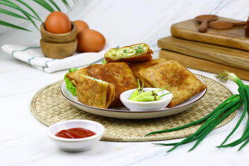 Martabak telur, Indonesian popular folded omelet made from egg, green onion, and wrapped with crispy dough. Isolated background.