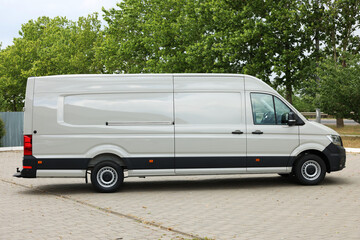 One white minibus parked on paved road outdoors