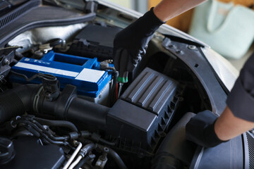 Auto parts. Professional mechanic with screwdriver fixing car indoors, closeup