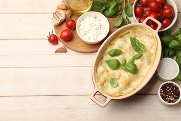Tasty vegetarian lasagna and ingredients on wooden table, flat lay. Space for text