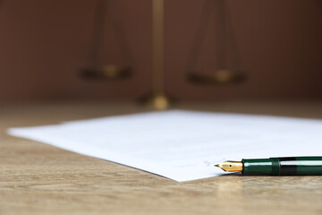 Notary document and fountain pen on wooden table against brown background, selective focus