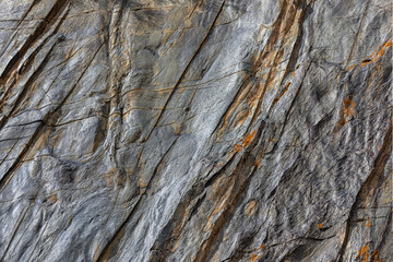 Rugged wavy sedimentary rock face texture and background