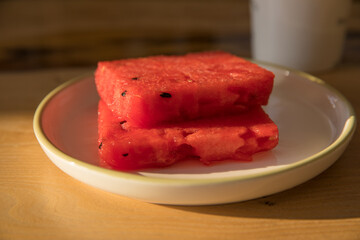 Even slices of sliced watermelon on a plate on a table