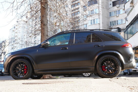 Bucharest, Romania &ndash; January 9, 2025: Closeup side view of Mercedes AMG Affalterbach luxury black car in crowded parking lot in residential area