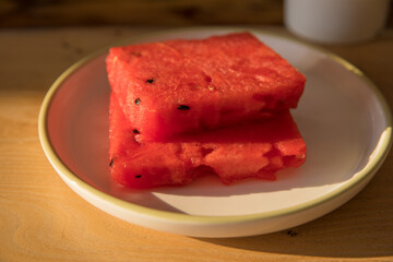 Even slices of sliced watermelon on a plate on a table