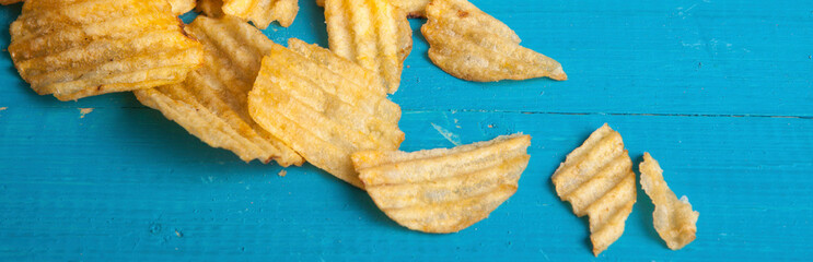 potato chips scattered on a blue wooden table