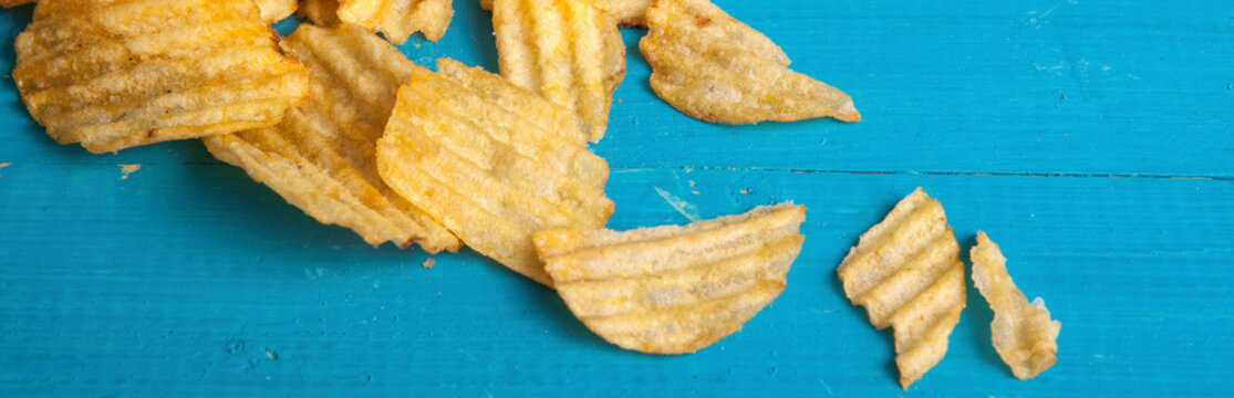 potato chips scattered on a blue wooden table