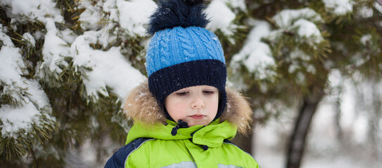 portrait of a little boy in a hat and jacket in winter