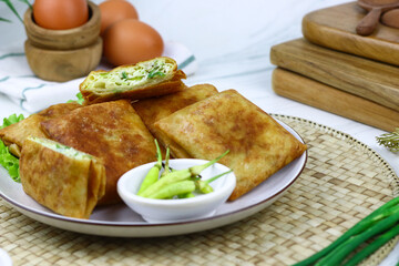 Martabak telur, Indonesian popular folded omelet made from egg, green onion, and wrapped with crispy dough. Isolated background.