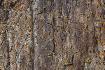 Rugged detailed sedimentary rock formation in mountainous Kyrgyzstan region during daytime - texture and background